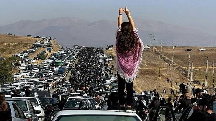 امرأة بلا حجاب تقف على إحدى السيارات في مراسم أربعينية أميني في مدينة "سقز"